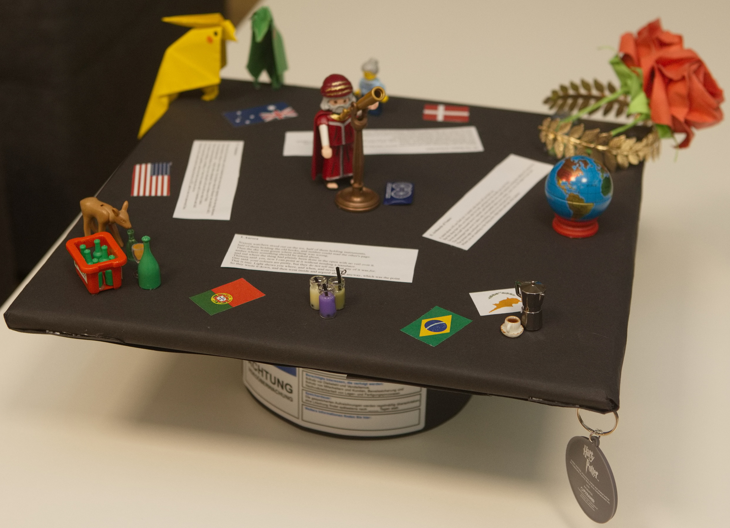 Close-up of the doctor hat, covered in flags, figurines and paper flowers
